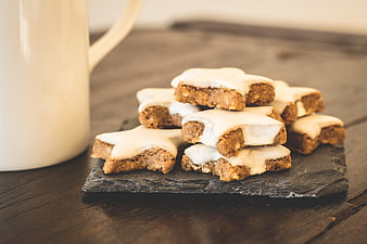 Star-shaped gingerbread cookies with white icing on slate