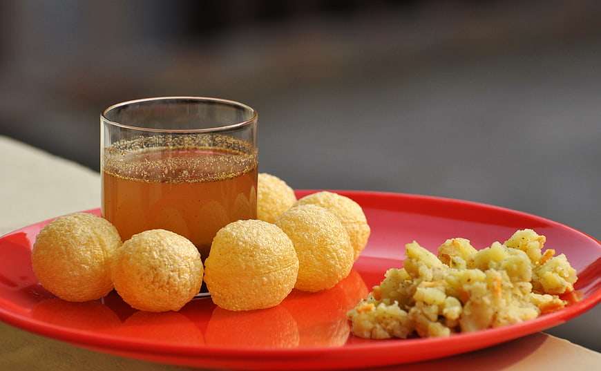 Traditional Indian Panipuri Snacks With Chutney On Red Plate