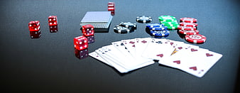 Poker chips, dice, and cards on a black table