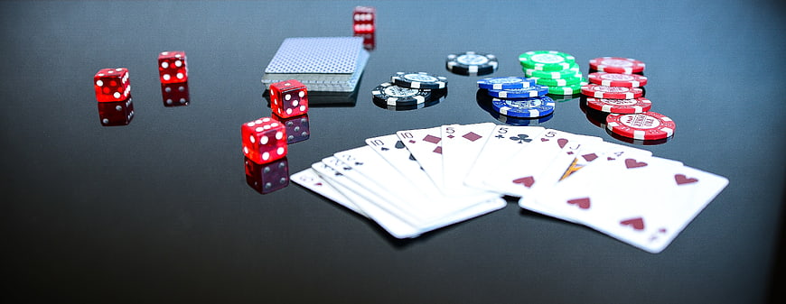 Poker chips, dice, and cards on a black table