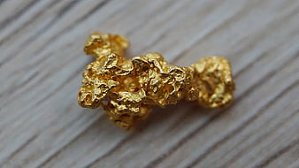 Raw Gold Nugget Macro Photography on Textured Wooden Surface