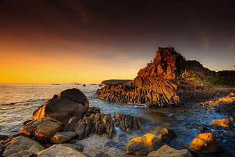 Dramatic Sunset Over Rocky Basalt Coastline