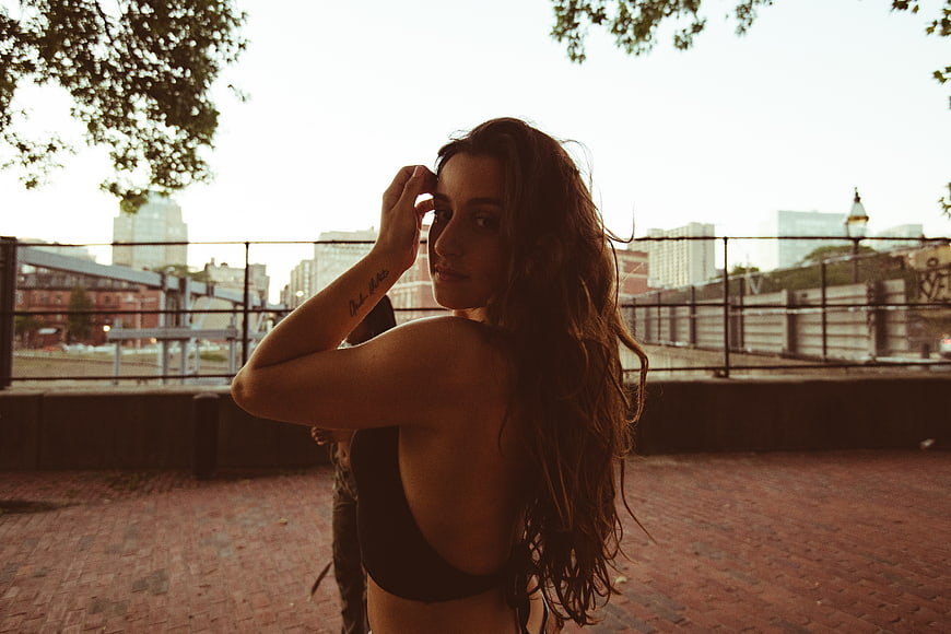 Brunette woman looking back on urban brick walkway