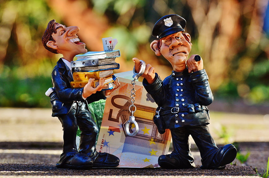 Tax Evasion Concept with Figurines, Handcuffs, and Euro Banknote