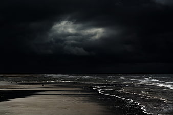 Dramatic Dark Storm Clouds Over Empty Beach and Sea