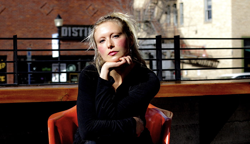 Blonde Woman Sitting on Outdoor Cafe Patio in Sunlight