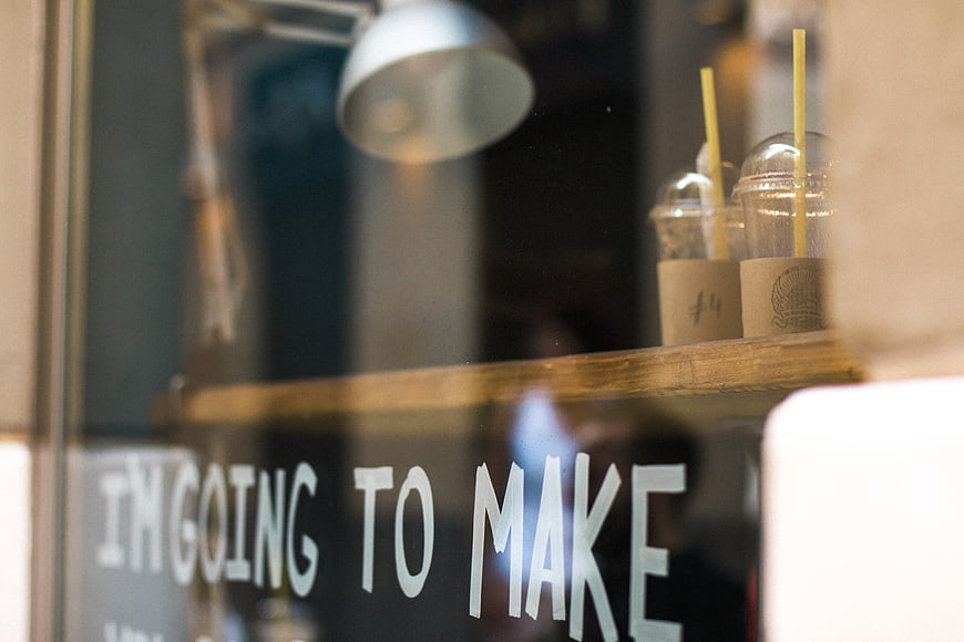 Coffee shop window with iced drinks and inspirational quote