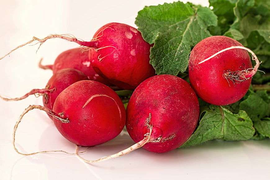 Fresh Red Radishes With Green Leaves On White Background