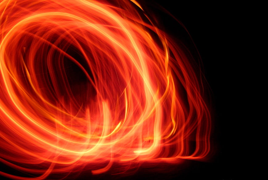 Abstract red and orange light painting swirls on black background