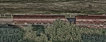 Rusty freight train cars on rural tracks