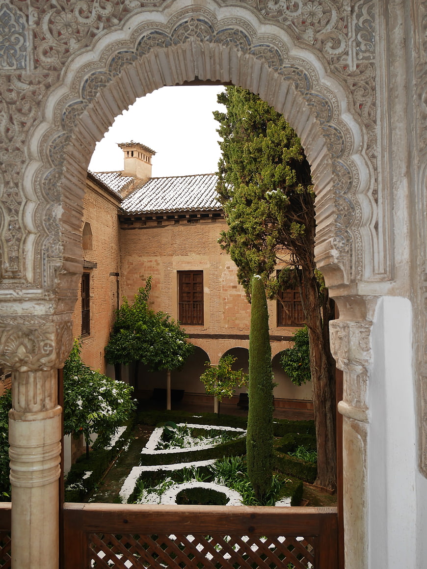 Ornate Moorish Archway Framing Historic Courtyard Garden