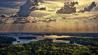 Aerial View of Forested Islands and Water Channels with Dramatic Sunbeams