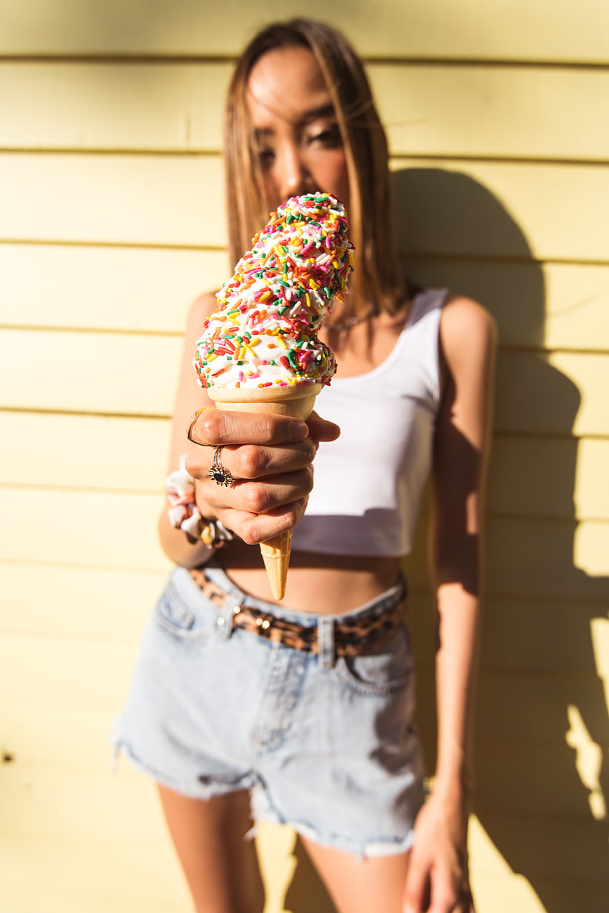 Woman holding ice cream cone with sprinkles