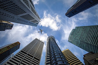 Low angle view of skyscrapers and airplane in Singapore