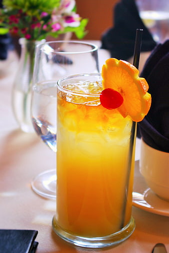 Refreshing Orange Cocktail with Cherry Garnish on Table