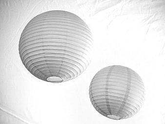 Two White Paper Lanterns Hanging Against White Background