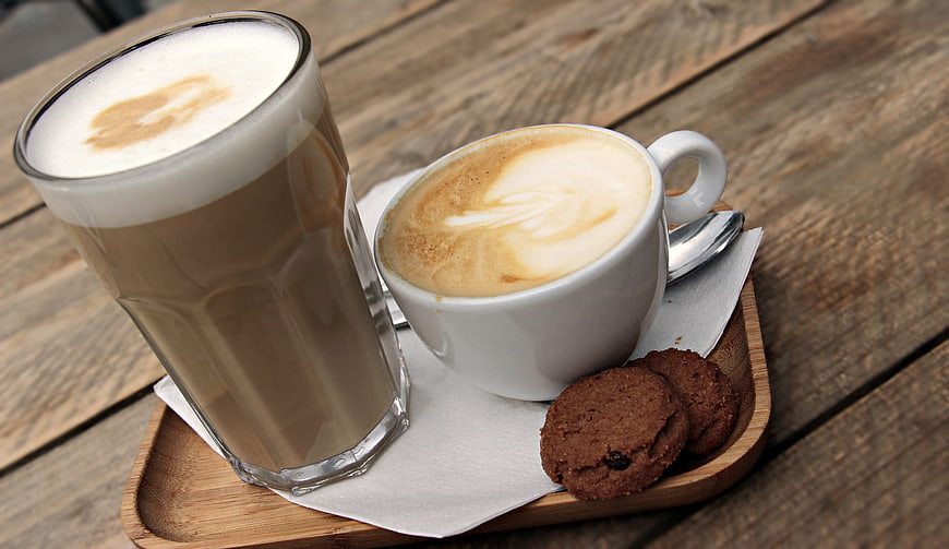 Latte Macchiato and Cappuccino with Cookies on Wooden Tray