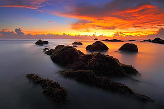 Dramatic Sunset Seascape with Smooth Misty Water and Rocks