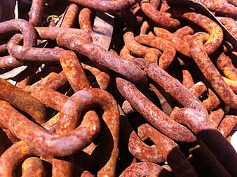 Close-up of heavy rusty iron chains in sunlight