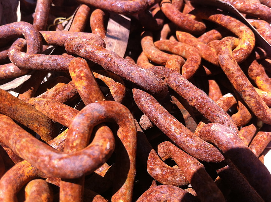 Close-up of heavy rusty iron chains in sunlight