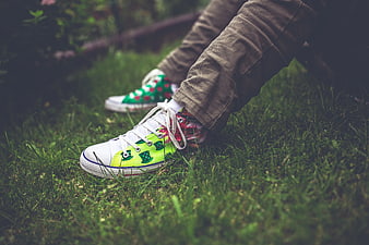 Colorful handmade sneakers on green grass