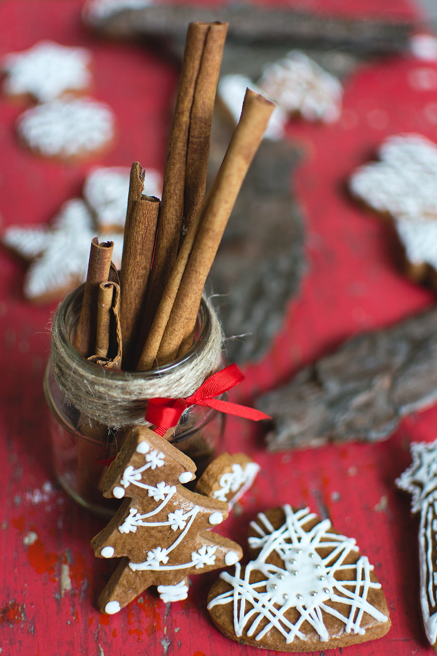 Homemade Gingerbread Cookies and Cinnamon Sticks on Red Table