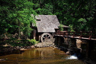 Historic wooden grist mill with water wheel by river