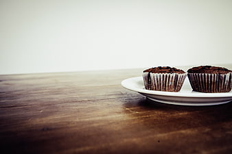 Two chocolate cupcakes on a white plate with copyspace