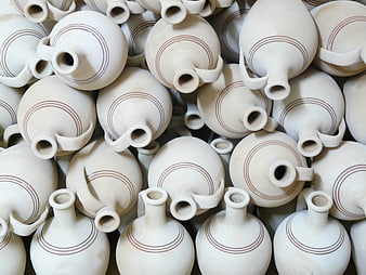 Close-up of white ceramic jugs with brown stripes