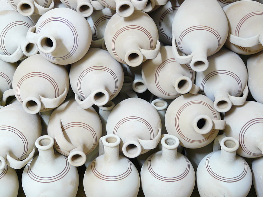 Close-up of white ceramic jugs with brown stripes