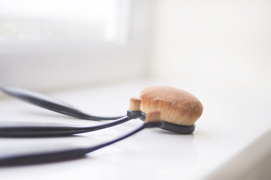 Close-up of makeup brushes on white surface
