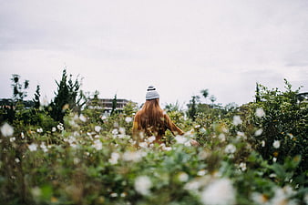 Woman with Red Hair Walking Through Wildflower Field