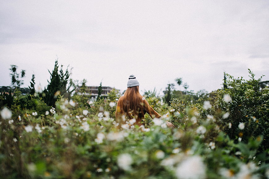Woman with Red Hair Walking Through Wildflower Field