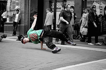 Breakdancer performing freeze move on city street