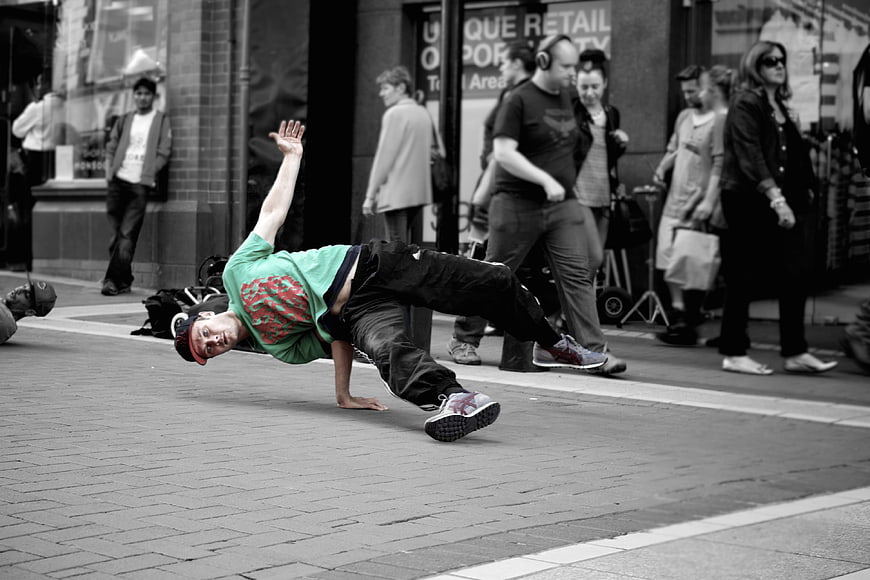 Breakdancer performing freeze move on city street