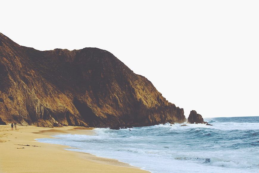 Dramatic coastal landscape with golden cliffs and crashing ocean waves