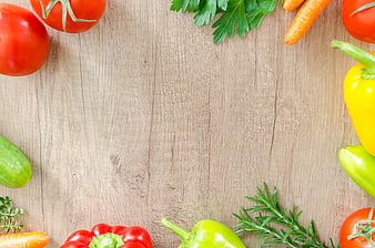 Fresh vegetables and herbs arranged on a wooden background