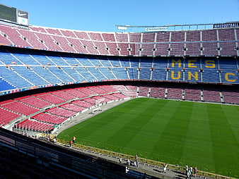 Camp Nou Football Stadium Interior With Colorful Seating And Green Pitch