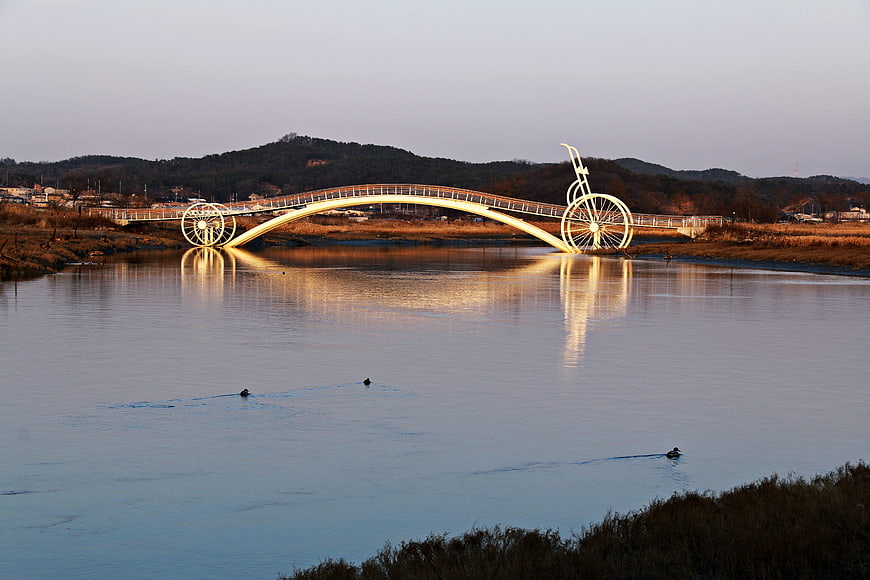 Bicycle Pedestrian Bridge Over Calm River At Dusk