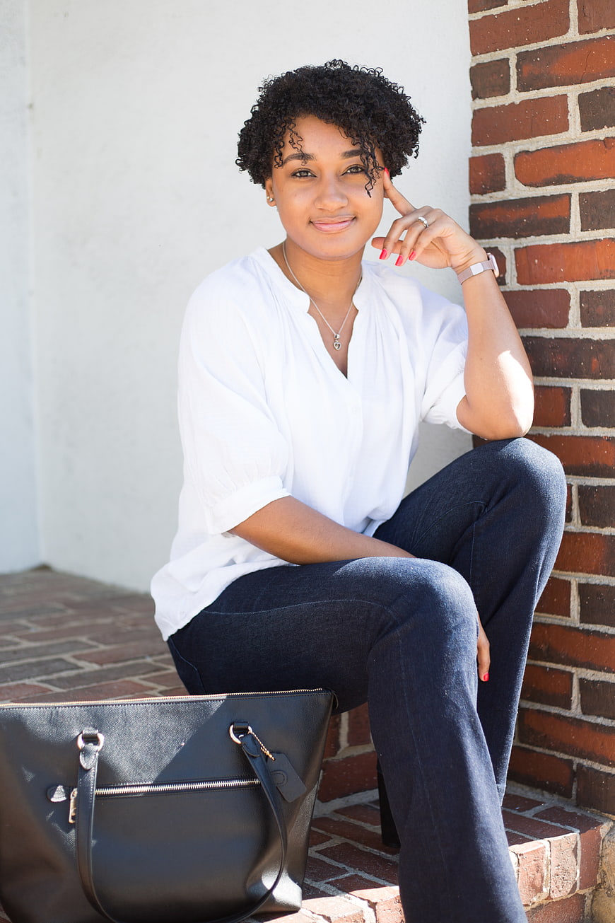 Confident Black Woman Sitting on Brick Steps with Handbag