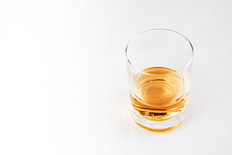 Glass of amber whiskey on white background