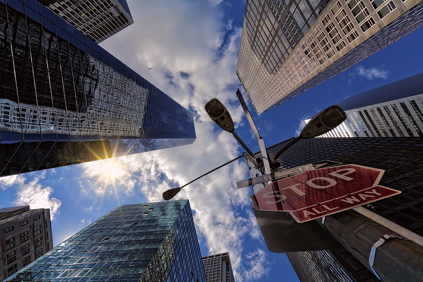 Low angle view of city skyscrapers and stop sign