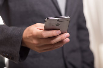 Close-up of businessman holding silver smartphone