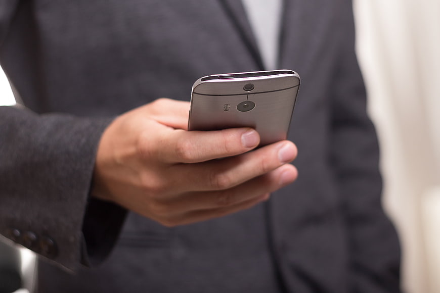 Close-up of businessman holding silver smartphone