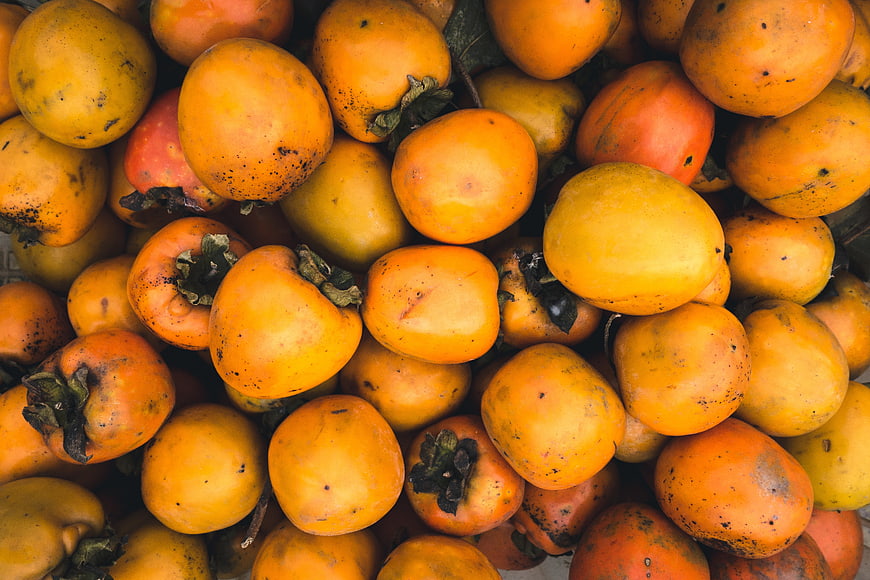 Top view of fresh persimmon fruits in a pile