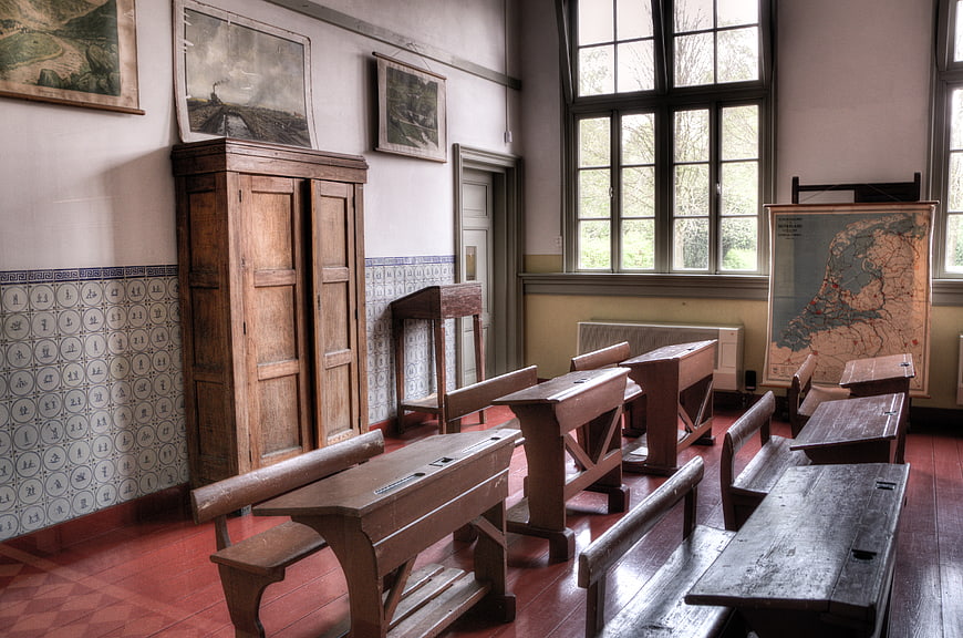 Vintage Classroom Interior with Wooden Desks and Maps