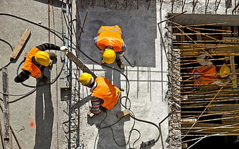 Aerial View of Construction Workers in Orange Vests and Yellow Hard Hats