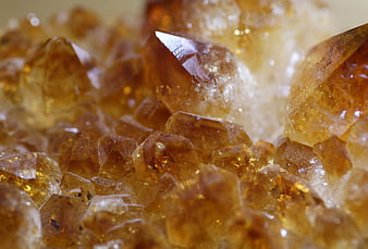 Macro shot of golden citrine crystals with sharp facets and warm amber tones