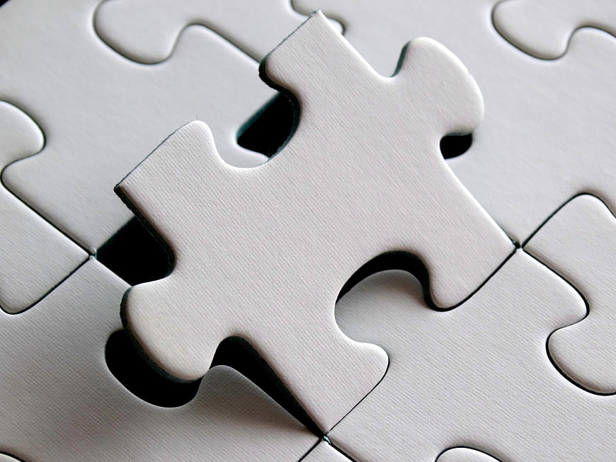 White Jigsaw Puzzle Piece Hovering Over Missing Gap