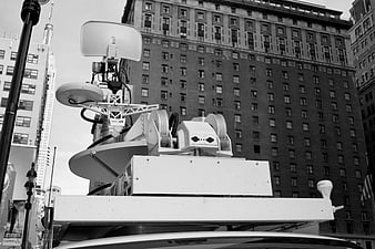 Black and white broadcast satellite dish on news van roof